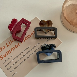 Three square acetate claw clips in burgundy, tortoiseshell, and navy with heart accents