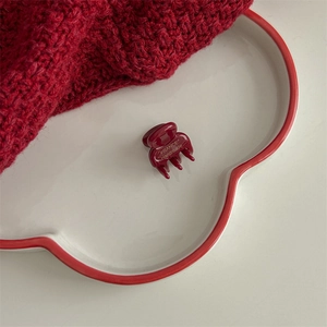 Macro shot of dark red acetate hair claw clip with gold France Handmade logo detail
