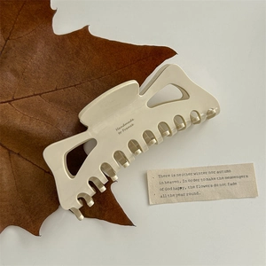 Detail showing creamy white acetate hair claw clip with Handmade in France text