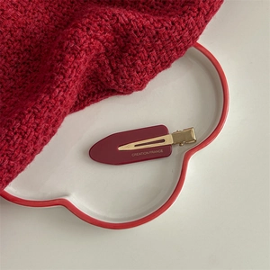 Detail view of burgundy acetate hair claw showing gold metal back and France lettering