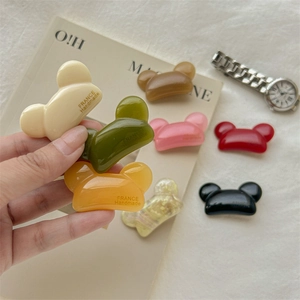 Main tenant des barrettes ours colorées en résine avec impression France Handmade