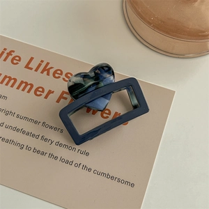 Close-up of a blue square hair claw clip with a colorful acetate heart decoration