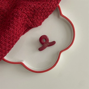 Detailed close-up of dark red acetate hair claw clip with golden France Handmade lettering