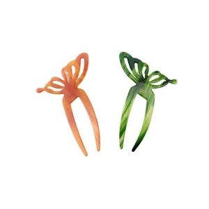 Elegant butterfly acetate hair pins in amber orange and marbled green for hair styling