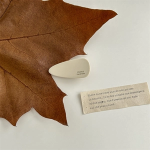 Detail of cream white acetate hair claw clip with France Handmade engraving and leaf decor