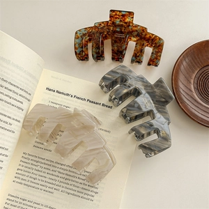 Three premium acetate claw clips in tortoiseshell and marble patterns for women's hair