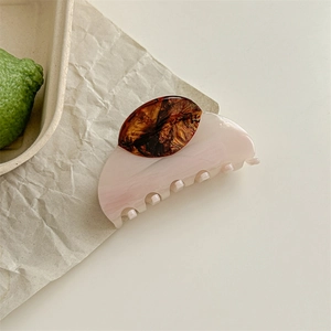 Detail showing the wood grain marble texture and tortoise shell finish of the hair claw clip
