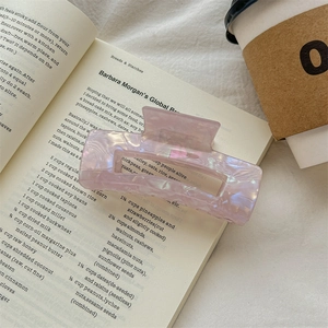 Detail of rectangular iridescent hair claw clip with pink purple pearlescent texture