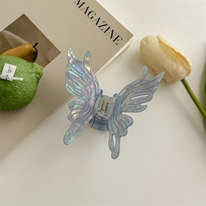 Détail de la pince à cheveux papillon bleu iridescent avec des ailes découpées élégantes