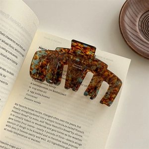 Detail of tortoise shell acetate claw clip with France Handmade text on open book