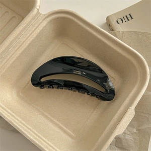 Detailed macro view of large black acetate hair claw with gold France Handmade logo
