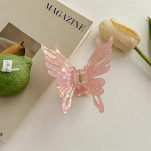 Détail de la pince à cheveux papillon rose irisée avec finition nacrée élégante
