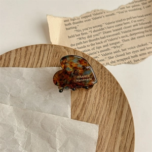 Détail d'une pince à cheveux cœur en acétate écaille avec gravure dorée à la main
