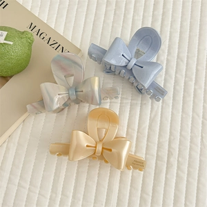 Chic bow-shaped acetate hair claws in pastel purple, marble, and cream yellow colors