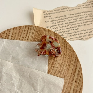 Détail d'une pince à cheveux en acétate faite main avec motif écaille et texte doré