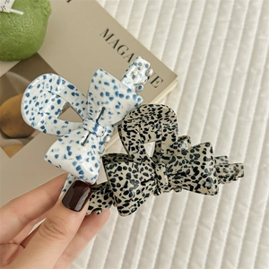 Elegant acetate bow hair claws with stylish spotted patterns for a modern hair styling look