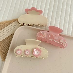 Detailed shot of acetate hair claws with rhinestones, flowers and bow designs