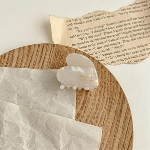 Détail d'une pince à cheveux en acétate en forme de cœur avec texte doré Handmade