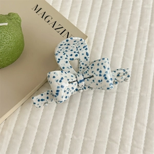Detail of blue speckled acetate bow hair claw clip with France Handmade lettering