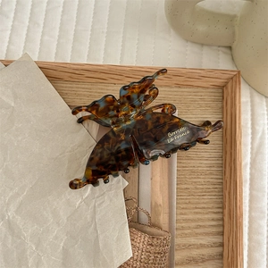 Macro detail of a vintage French acetate butterfly hair claw with brown tortoiseshell pattern