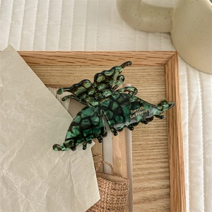 Detailed view of dark green butterfly hair claw clip with golden Barrette La France text
