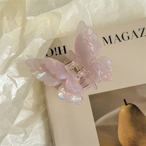 Detailed macro view of pearlescent butterfly hair claw with iridescent purple finish