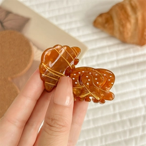 French vintage croissant style amber resin hair claw clip with golden texture details