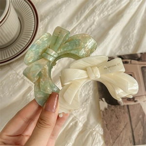 Handmade acetate bow hair claw clips in marble mint green and pearlescent cream white