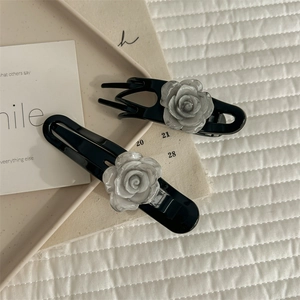 Elegant 2-piece black camellia hair clip set with white rose flower decor on tray