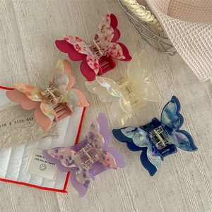 Elegant butterfly hair claws in acetate marble finish with strong gold metal spring