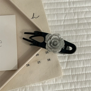Detailed view of camellia hair claw clip with black finish and marble flower texture