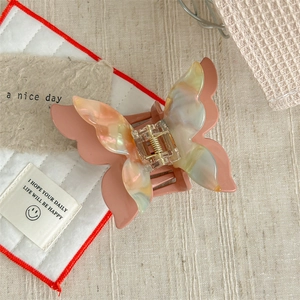 Close-up of pink butterfly hair claw clip with colorful marble texture and gold metal spring