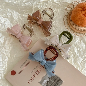 French acrylic bow hair claws in pink, brown, white, and blue with stitched texture detail