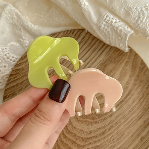 Elegant wavy acetate hair claws in lime green and pale pink for half-up hairstyles