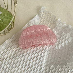 Dettaglio molletta per capelli in acetato con trama marmo rosa per acconciature eleganti