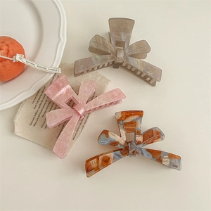 Three-piece set of elegant bow hair claws in marble and tortoiseshell patterns