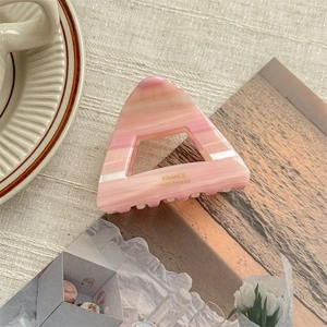 Detail showing marble pink acetate hair claw with gold France Handmade logo