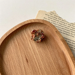 Détail macro de la pince à cheveux fleur en acétate écaille sur un plateau en bois