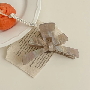 Macro detail of the bow hair claw clip featuring grey and beige marble texture