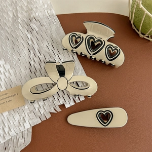 Sweet heart cutout and bow hair claw clip set in creamy white with black accents