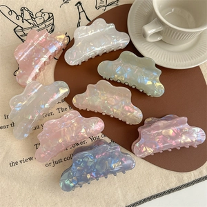Huit pinces à cheveux irisées en forme de nuage aux couleurs nacrées sur un tapis doux