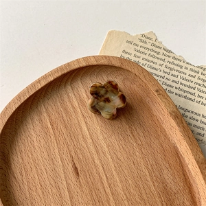 Détail d'une petite pince à cheveux fleur en acétate faite main avec motifs d'écaille ambrée