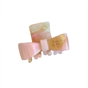 Pink marble acetate bow hair claw clip with pearlescent finish for elegant hairstyles
