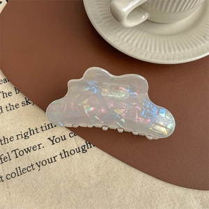 Détail d'une pince à cheveux nuage avec texture nacrée irisée et reflets brillants dégradés