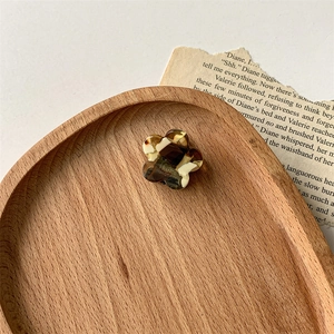 Détail d'une pince à cheveux fleurie en acétate faite main avec texture écaille chic