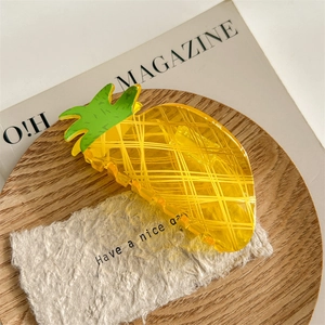 Gros plan détaillé d'une pince à cheveux en forme d'ananas en acrylique jaune