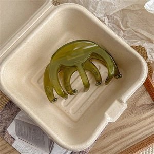 Macro detail of dark green translucent hair claw clip with France Handmade engraving