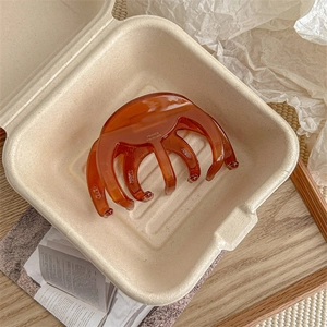 Detail of amber translucent hair claw clip with golden France Handmade lettering