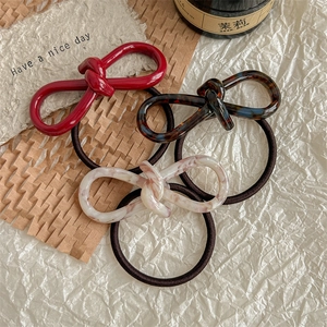 Three-piece acetate bow hair tie set in red, tortoiseshell, and marble patterns