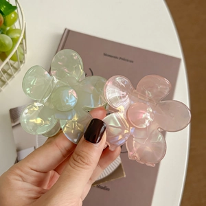 Pinces à cheveux à fleurs vert et rose irisé, montrant le design des pétales translucides